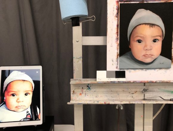Painting on easel with reference photo on iPad